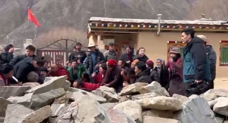 Monks and residents of Upper Wonto Village plead with officials outside Yena Monastery